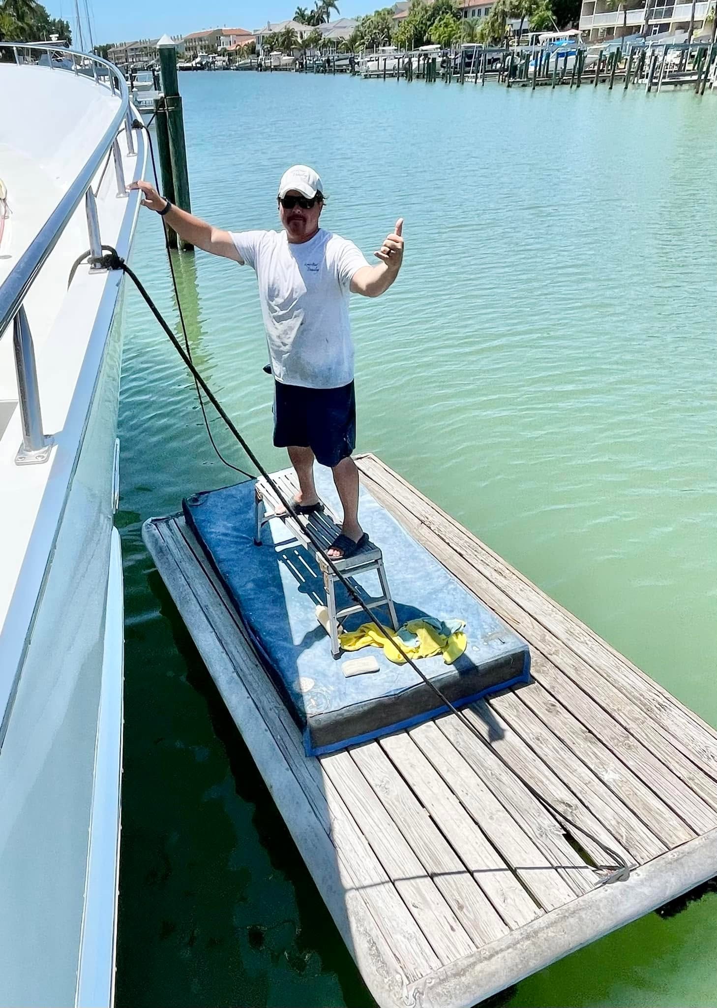 Technician working in the water alongside a vessel during detailing